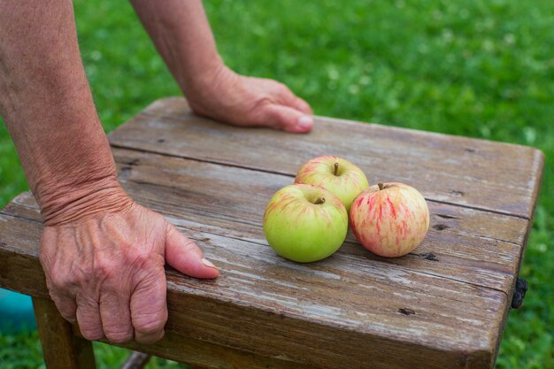 Hay tres manzanas frescas en un taburete de madera. Cosechando el concepto de comida sana