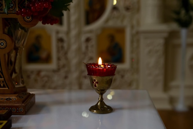 Hay una vela encendida en la mesa de la iglesia.