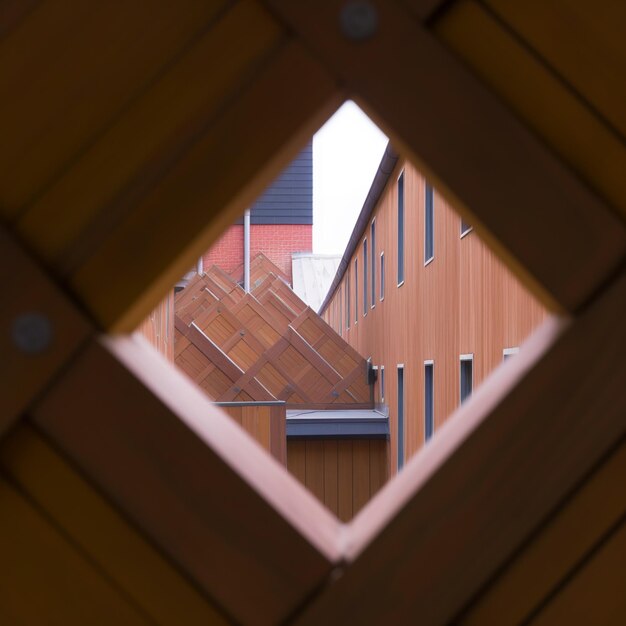 Hay una vista de un edificio a través de una ventana en una estructura de madera generativa ai