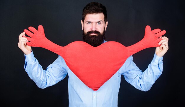 Foto haz que se sienta amado todos los días hombre barbudo hipster abraza corazón celebra el día de san valentín chico con barba y bigote enamorado estado de ánimo romántico sentir amor concepto de citas y relaciones feliz en el amor