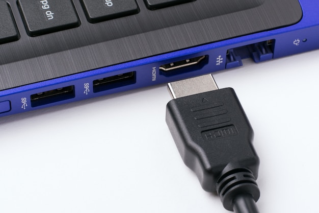 HDMI-Kabel in der Nähe des HDMI-Anschlusses des modernen blauen Laptops.