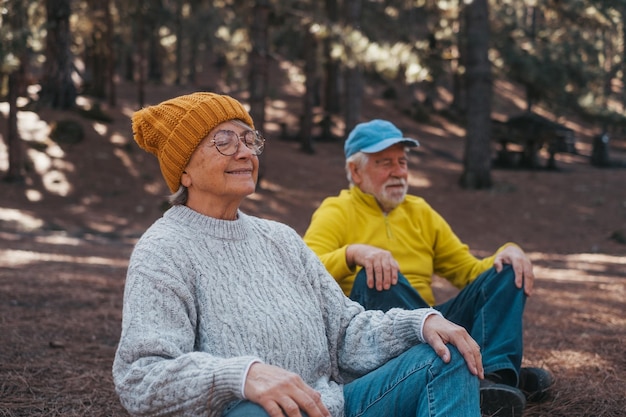 Head Shot Portrait Nahaufnahme von zwei alten Senioren mittleren Alters, die in den Bergen mitten im Wald im Freien meditieren und entspannen Zwei reife Personen, die sich amüsieren, entspannen sich