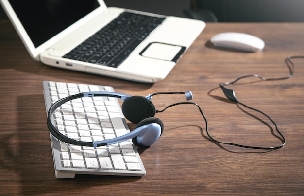 Headset de serviço ao cliente teclado de computador e objetos de negócios no fundo azul