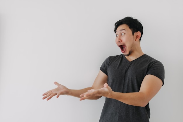 Headshot de cara de choque homem de camisa preta de pé isolado em branco