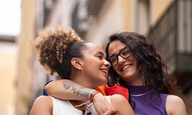 Headshot de duas mulheres lésbicas multiétnicas apaixonadas abraçadas e sorrindo desfrutando do tempo juntos