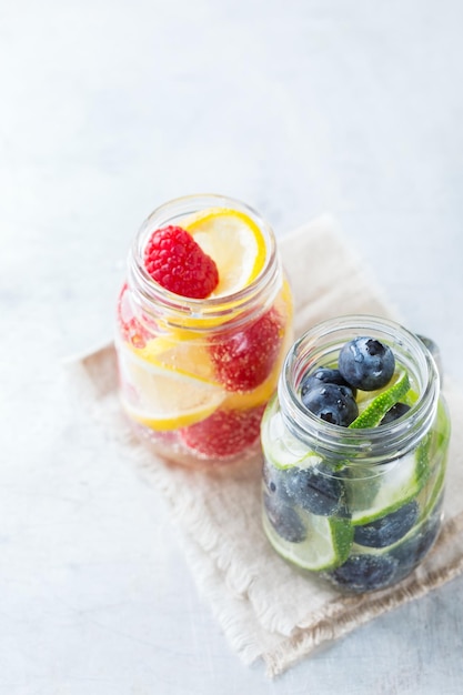 Health Care Fitness gesunde Ernährung Ernährung Konzept Frische kühle Zitrone Limettenbeeren Himbeere Heidelbeere mit Wassercocktail Detox-Getränk Limonade für Frühlings-Sommertage Kopieren Sie den Raumhintergrund