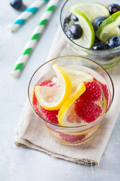 Health Care Fitness gesunde Ernährung Ernährungskonzept Frische kühle Zitrone Limettenbeeren Himbeere Blaubeere mit Wassercocktail Entgiftungsgetränk Limonade für Frühlingssommertage