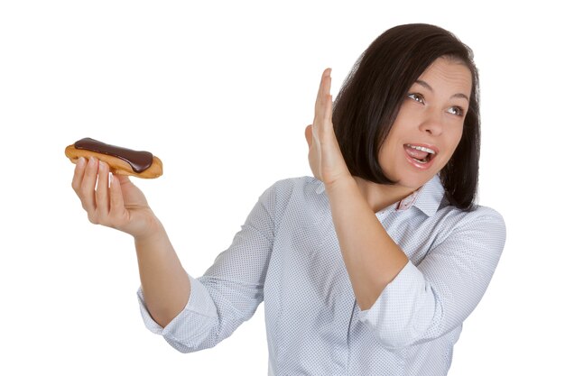 Health-Food-Konzept. Schöne hübsche junge Frau, die sich weigert, Schokoladen-Eclair auf weißem Hintergrund zu essen