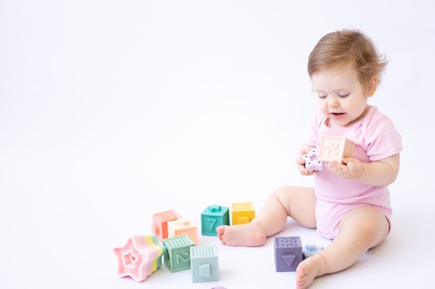 Healthybaby sitzt und spielt mit bunten Würfeln auf weißem Hintergrund ein Platz für Text