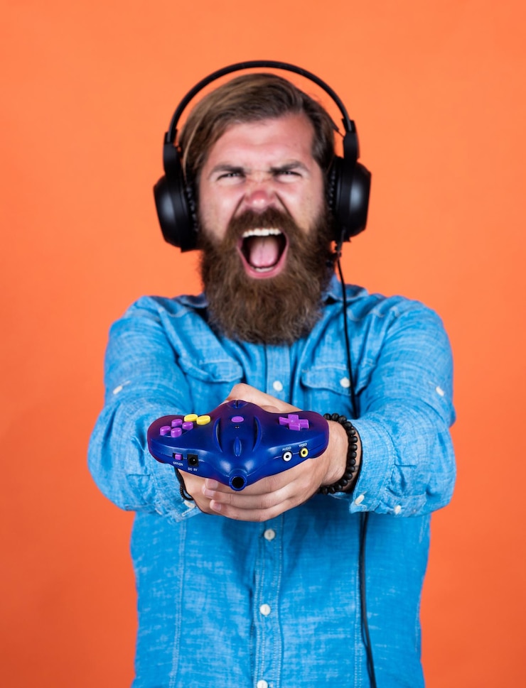 Foto heart of perfect gaming jogando online relaxe com passatempo favorito homem barbudo gamer homem alegre usar fones de ouvido modernos masculinos em fones de ouvido com conceito de jogos de computador de console de jogos