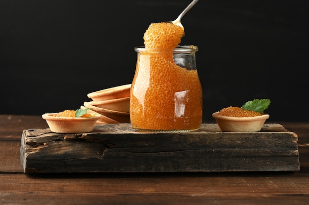 Hechtkaviar in einem Glas und runden Törtchen