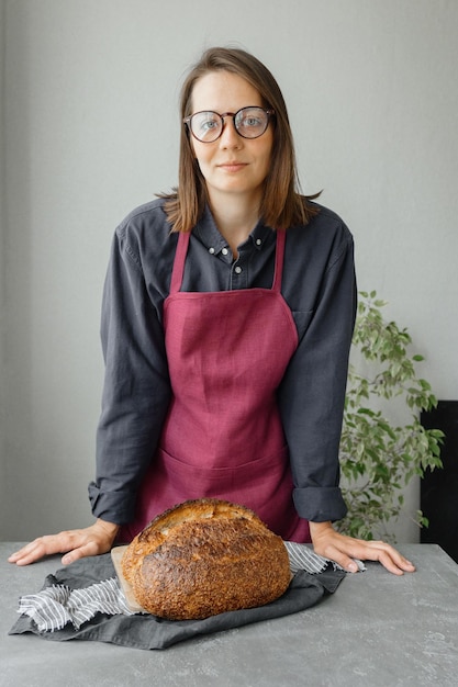 Foto hefefreies sauerteigbrot eine schöne europäische bäckerin hält brot in ihren händen