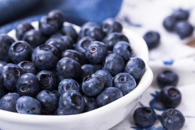 Heidelbeeren in einer weißen Keramikschale auf Jeansstoff