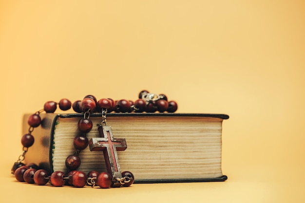 Heilige Bibel mit alten Perlen auf einem gelben Hintergrund Tisch Religionskonzept