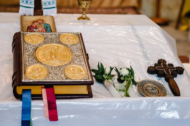 Heilige Bibel und Kreuz auf dem Tisch in der göttlichen Liturgie der Kirche