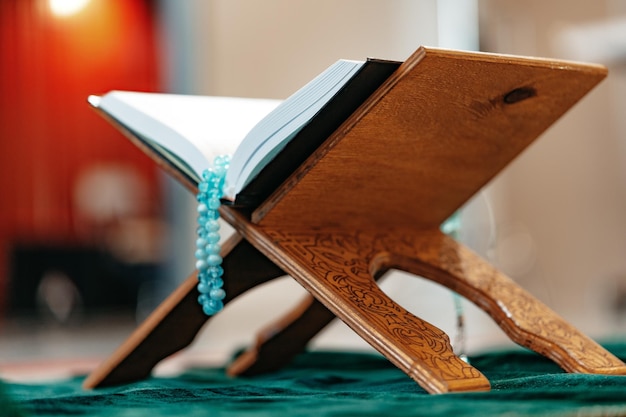 Foto heiliger koran mit rosenkranz auf einem holzstand