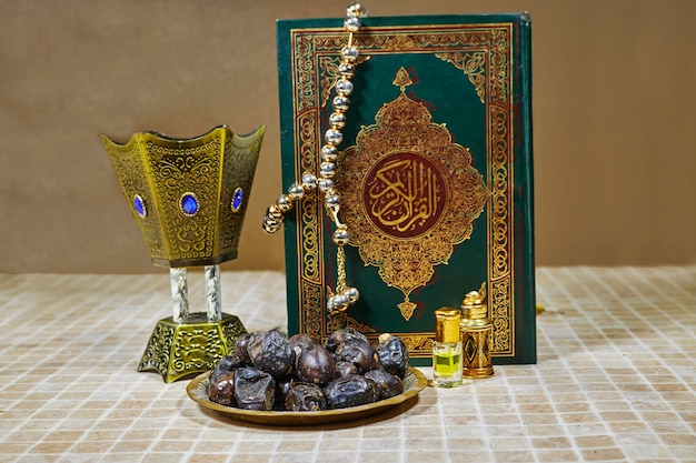 Heiliges Buch der Muslime und Oud-Parfüm und Räuchergefäß, Datteln, Obst-Tasbih