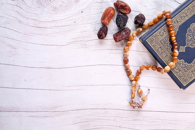 Heiliges Buch Koran und Dattelfrucht auf Holztisch