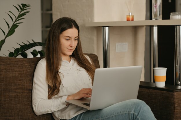 Heimarbeit. Eine kaukasische Frau, die fern an ihrem Laptop arbeitet.