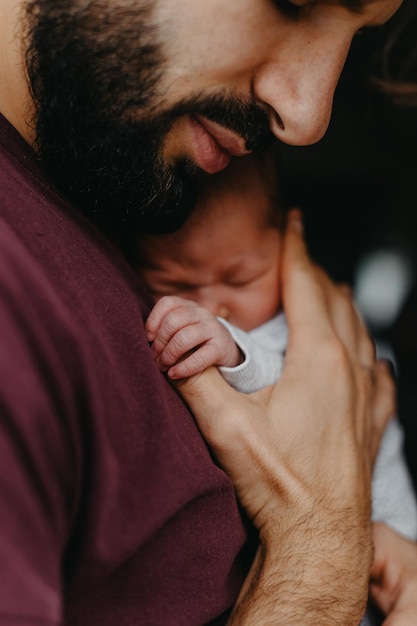Heimfotos eines neugeborenen Babys in den Armen des Vaters Selektiver Fokusrauscheffekt