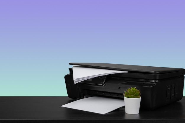 Heimlaserdrucker auf dem Schreibtisch vor violettem Hintergrund