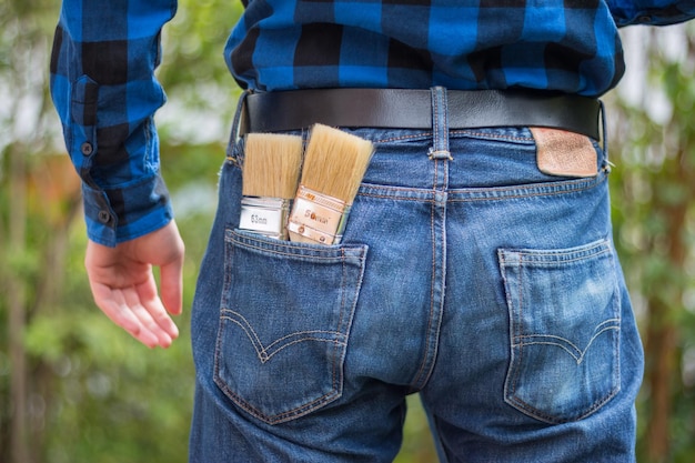 Heimwerker Rückansicht eines jungen Mannes mit Pinseln in der Tasche