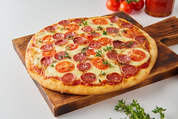 Heiße hausgemachte italienische Peperoni-Pizza mit Salami, Mozzarella auf weißem Tisch, Seitenansicht