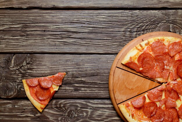 Heiße hausgemachte Pepperoni-Pizza auf dem Holztisch