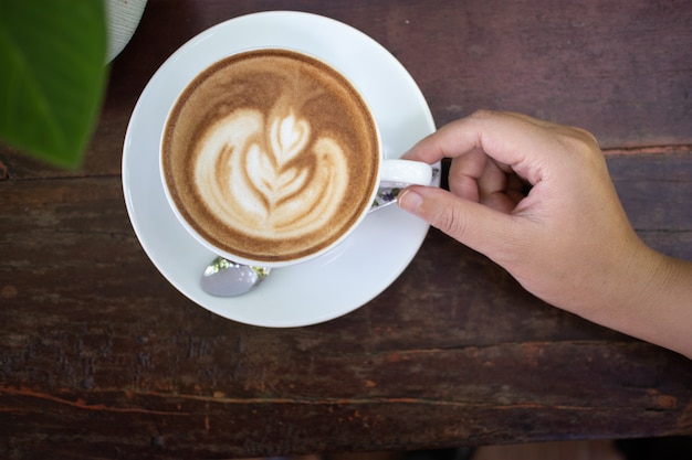 heiße Kaffee Lattekunst auf dem Holztisch im Wald