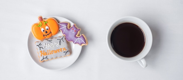 Heiße Kaffeetasse mit lustigen Halloween-Plätzchen. Fröhlicher Halloween-Tag, Trick oder Bedrohung, Hallo Oktober, Herbstherbst, Traditions-, Party- und Urlaubskonzept