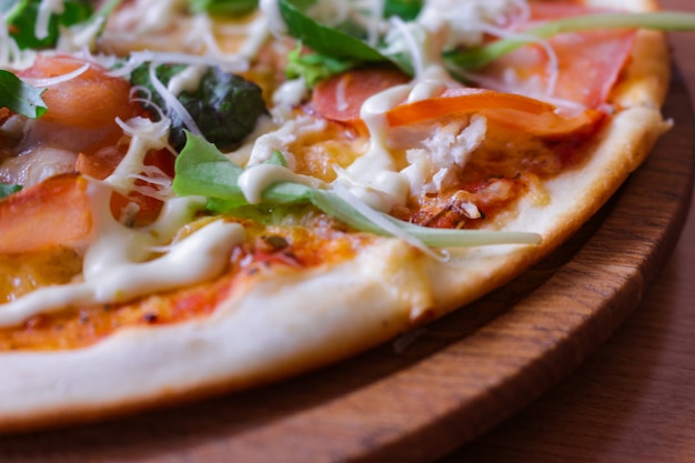 Foto heiße leckere pizza mit rucola, tomaten und speck