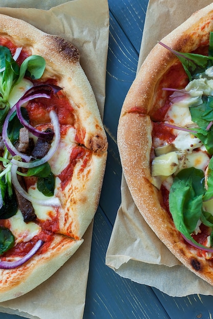 Heiße leckere Pizzen, Draufsicht. Peperoni auf Holztisch. Leckeres italienisches Essen.