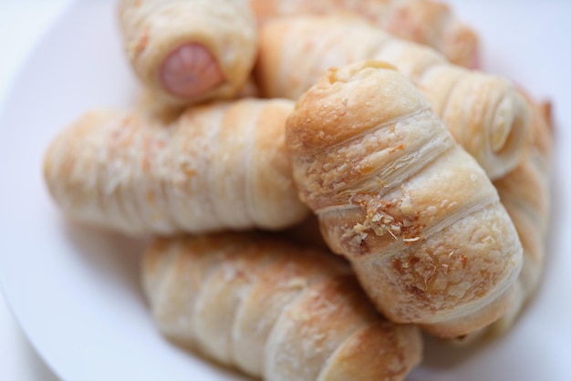 Heiße leckere Würstchen im Teig auf einem Teller-Puff-Brötchen