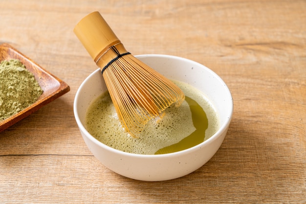 heiße Matcha-Grüntee-Tasse mit Grüntee-Pulver und Schneebesen