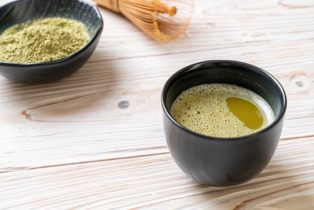 heiße Matcha-Grüntee-Tasse mit Grüntee-Pulver und Schneebesen