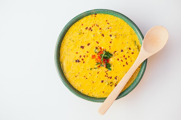 Heiße sahnige köstliche Suppe mit dem Grün und Gemüse, Holzlöffel auf Schüssel