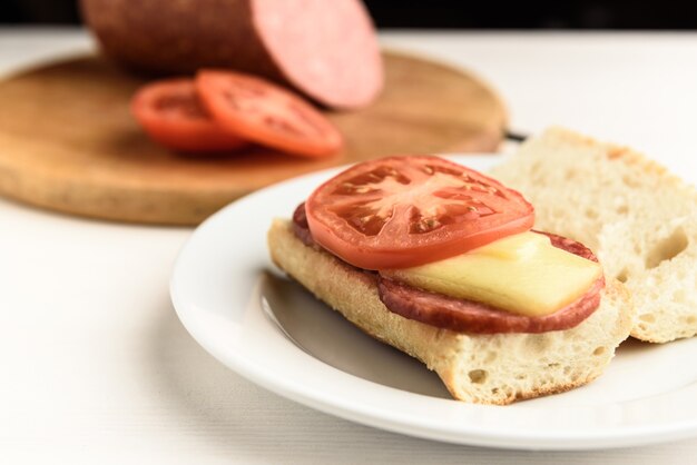 Heiße Sandwiches mit geschmolzener Käsewurst, Salami und Tomaten