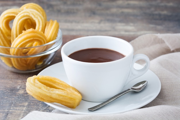 Heiße Schokolade mit Churros auf spanischem Frühstück des Holztischs