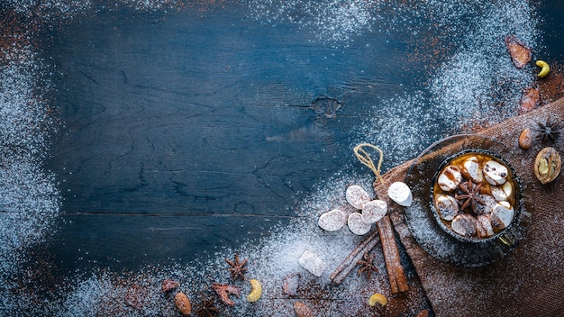 Heiße Schokolade mit Marshmallow-Nüssen Gewürze Schokolade Konfeti Zimt Auf dem schwarzen Holzschreibtisch