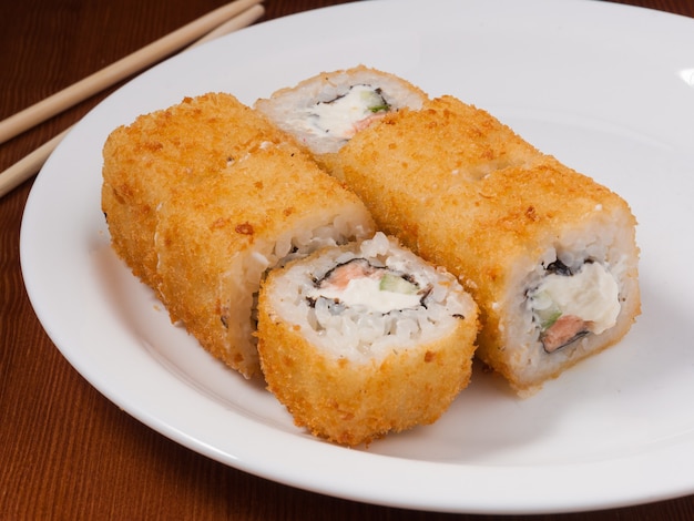 Heiße tempura-sushi-rolle mit lachs auf einem weißen teller