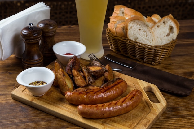 Heiße Würstchen auf Holzbrett mit Bier