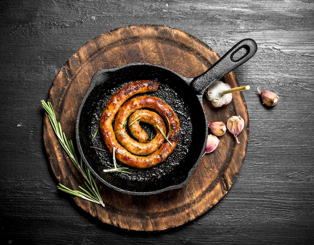 Heiße Würstchen in einer Pfanne an der schwarzen Tafel