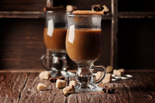 Heißer amerikanischer Kaffee mit Zimt auf dem Weinlese-Tisch