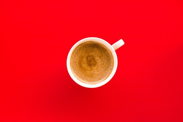 Heißer aromatischer Kaffee auf rotem Hintergrund flatlay