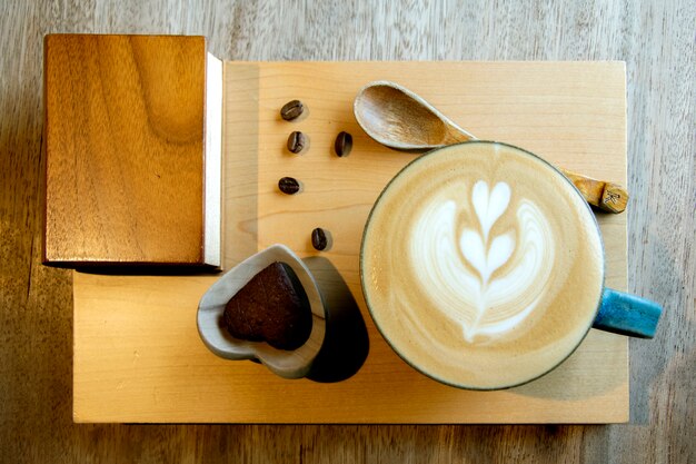 Heißer Cappuccino in der Schale auf Holztisch mit Kopieraum. Die Latte Art On-Kaffeehintergrund.