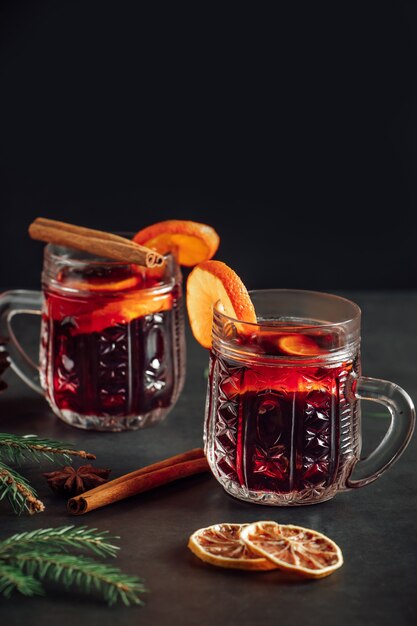 Heißer Glühwein in einer Glastasse. Warmes Wintergetränk mit Gewürzen und Früchten.