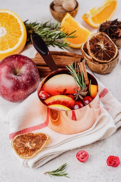 Foto heißer glühwein mit früchten und gewürzen in einem kupfertopf