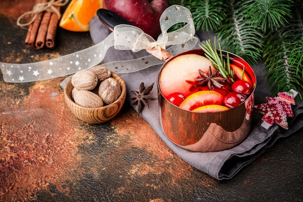 Heißer Glühwein mit Früchten und Gewürzen in einem Kupfertopf