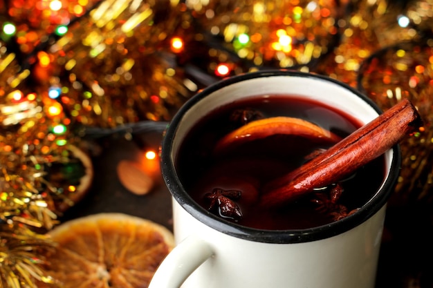 Foto heißer glühwein mit zimt und orange nahaufnahme auf dunklem hintergrund. weihnachten. neujahr.