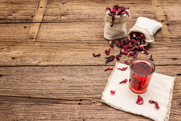 Heißer Hibiskus-Tee. Trockene Blütenblätter, Leinensäcke. Gesundes Essen und Self-Care-Konzept.